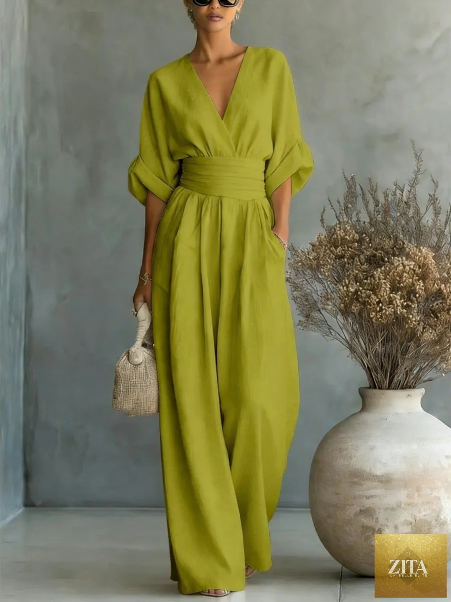 Women's V-neck wide-leg jumpsuit by MERIDGE featuring high waist, pleated design, elegant style, and flowing fabric.