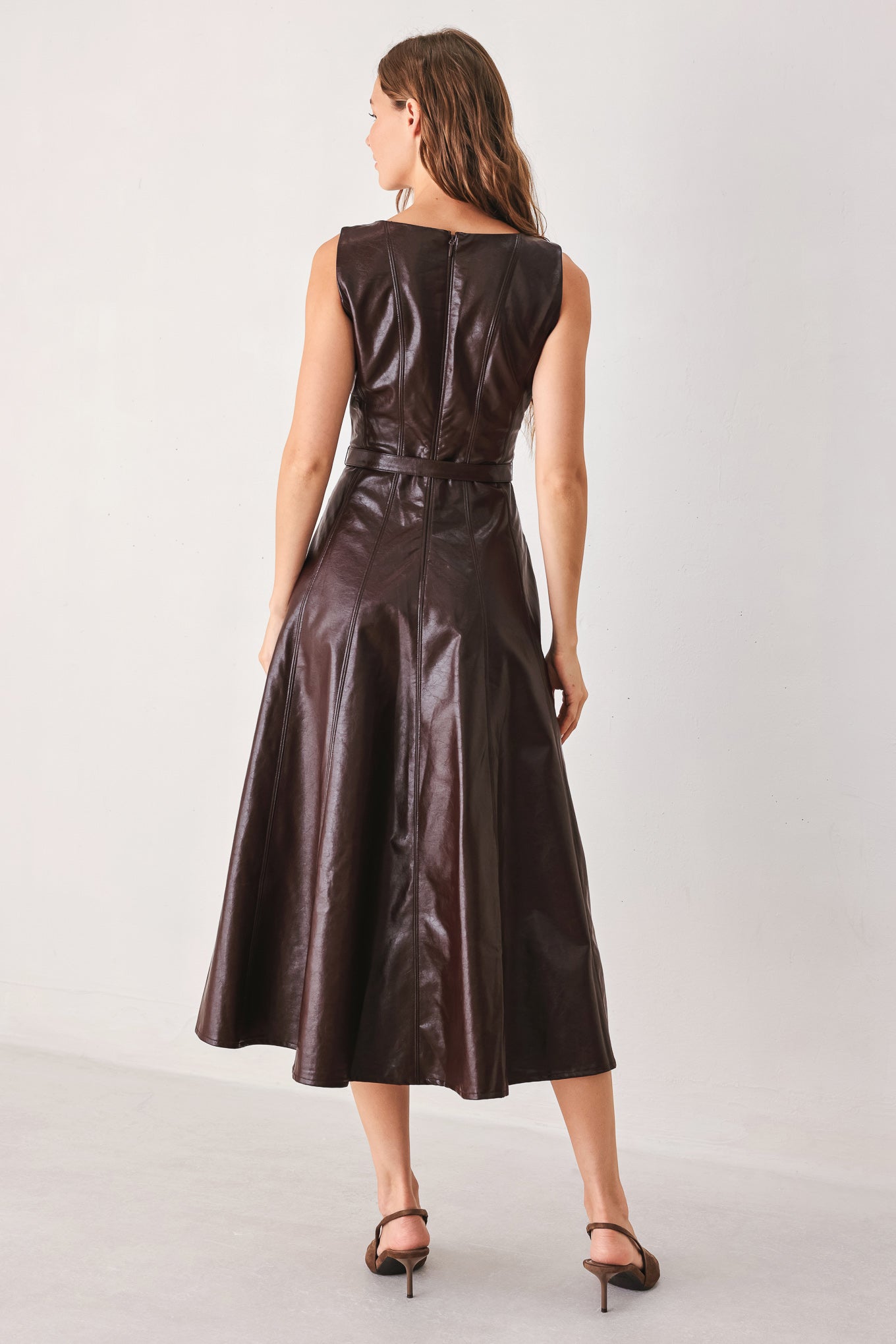 Dark brown faux leather midi dress by Flying Tomato, with a fitted silhouette and stylish design, displayed on a dress form.