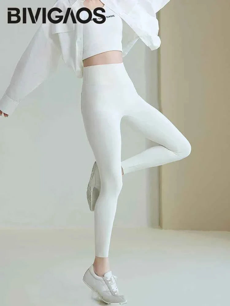White BIVIGAOS women's sharkskin leggings by THRIXINE featuring a sleek, form-fitting design with sharkskin textured fabric.