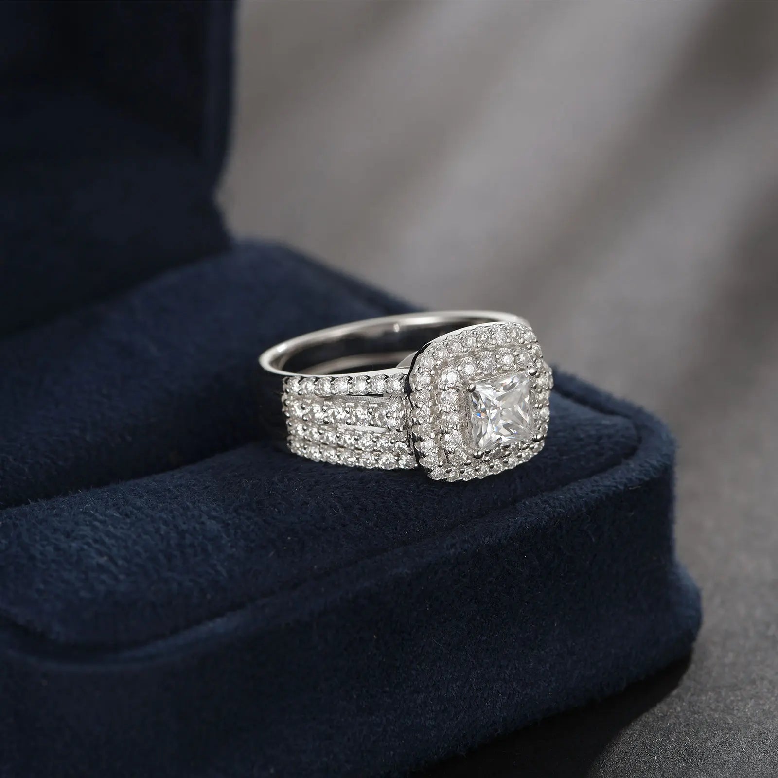 Elegant women's moissanite wedding ring set featuring halo princess cut stones in sterling silver with a luxury design.