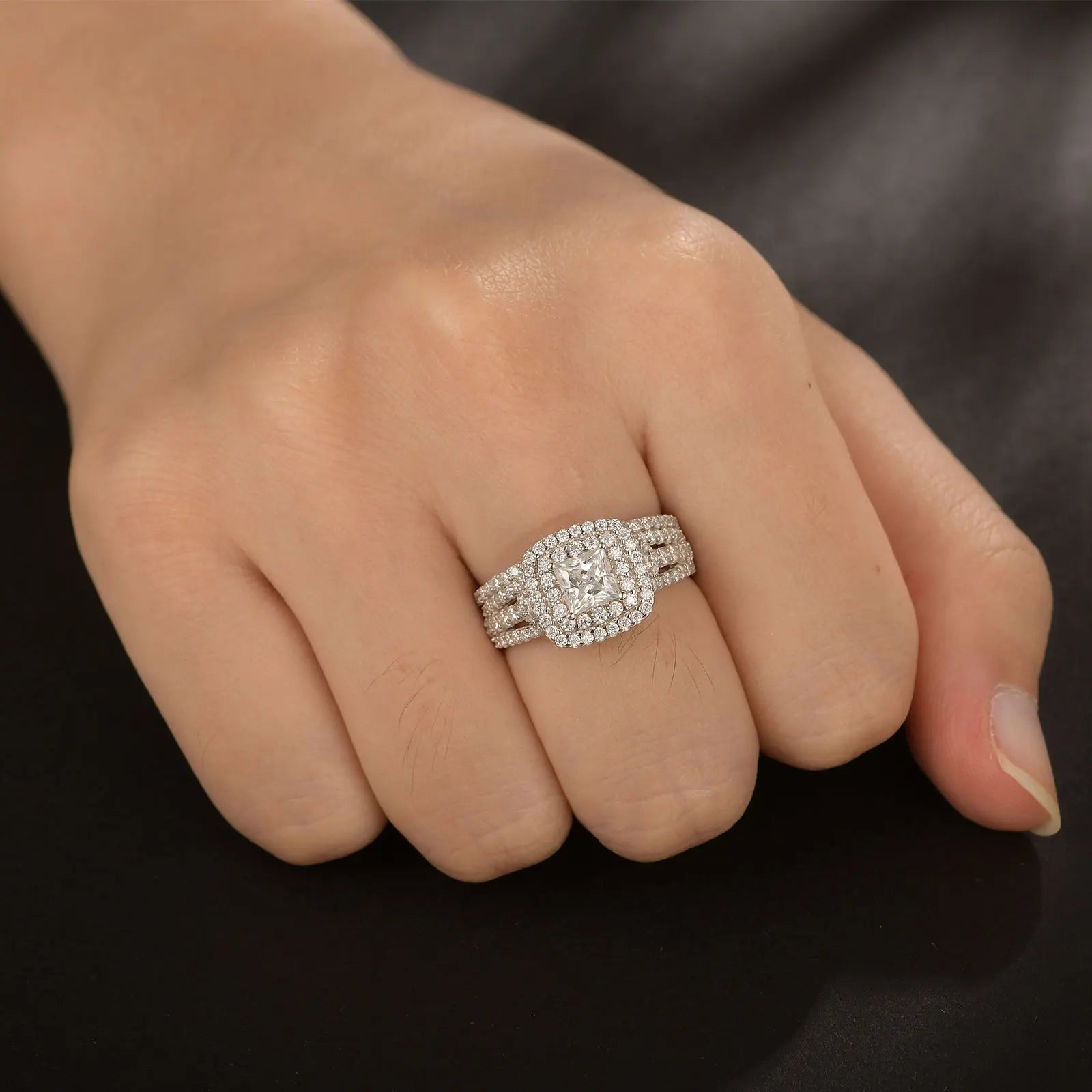 Elegant women's moissanite wedding ring set featuring a princess cut halo design in sterling silver with luxurious sparkle.