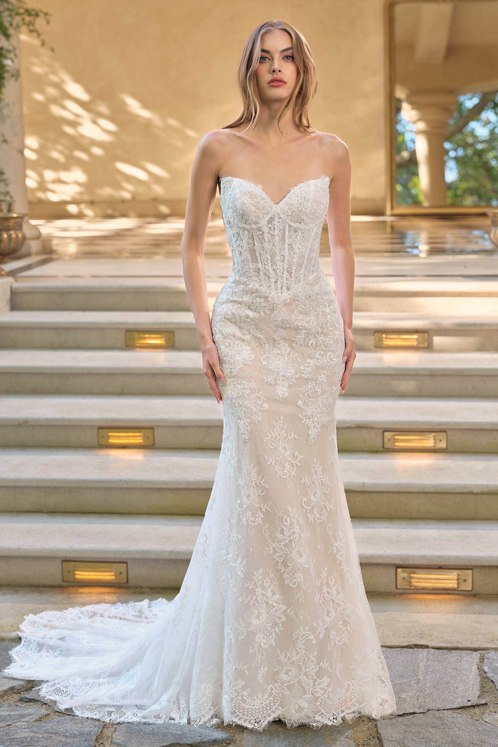 Elegant white fit and flare lace wedding dress with nude accents, paired with a matching lace bolero jacket.