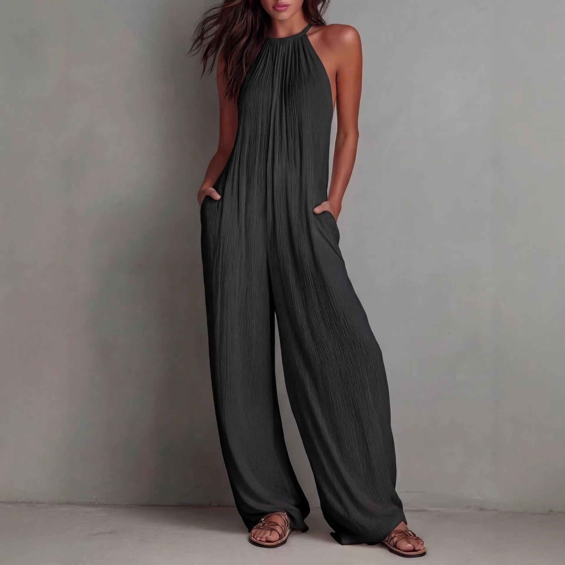 Women's sleeveless open-back wide-leg pleated jumpsuit by FitiqueFit, featuring a casual style with flowing fabric and stylish design.