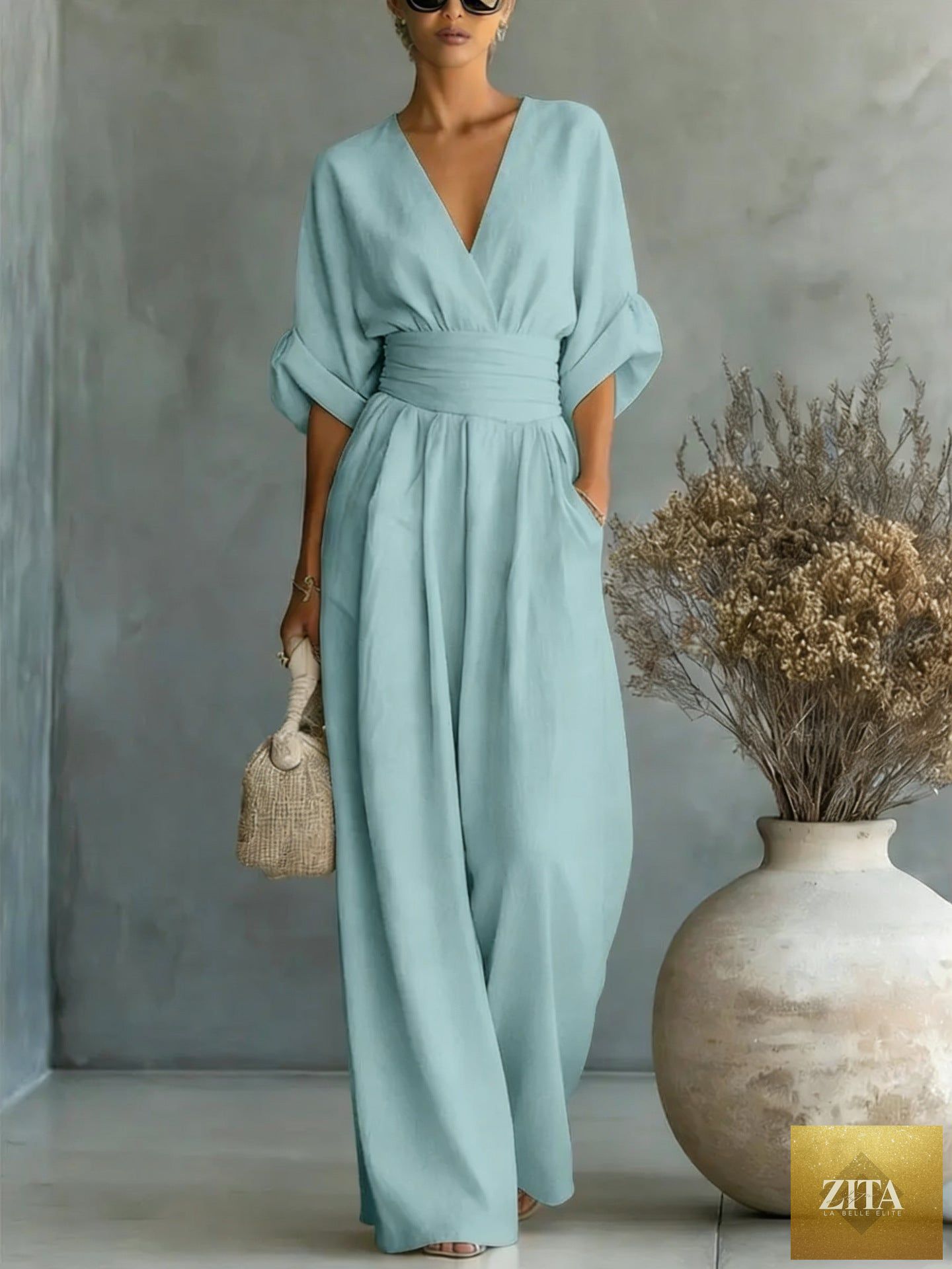 Women's MERIDGE V-neck wide-leg jumpsuit with high waist and pleated design, shown in a stylish and elegant silhouette.