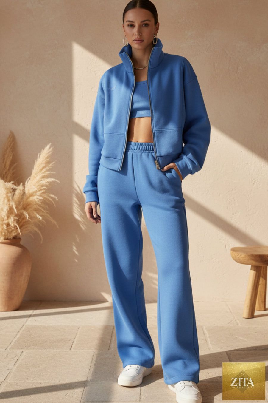 Women’s full-zip cropped sweatshirt and wide-leg fleece pants set by MERIDGE, shown on a model in a casual indoor setting.
