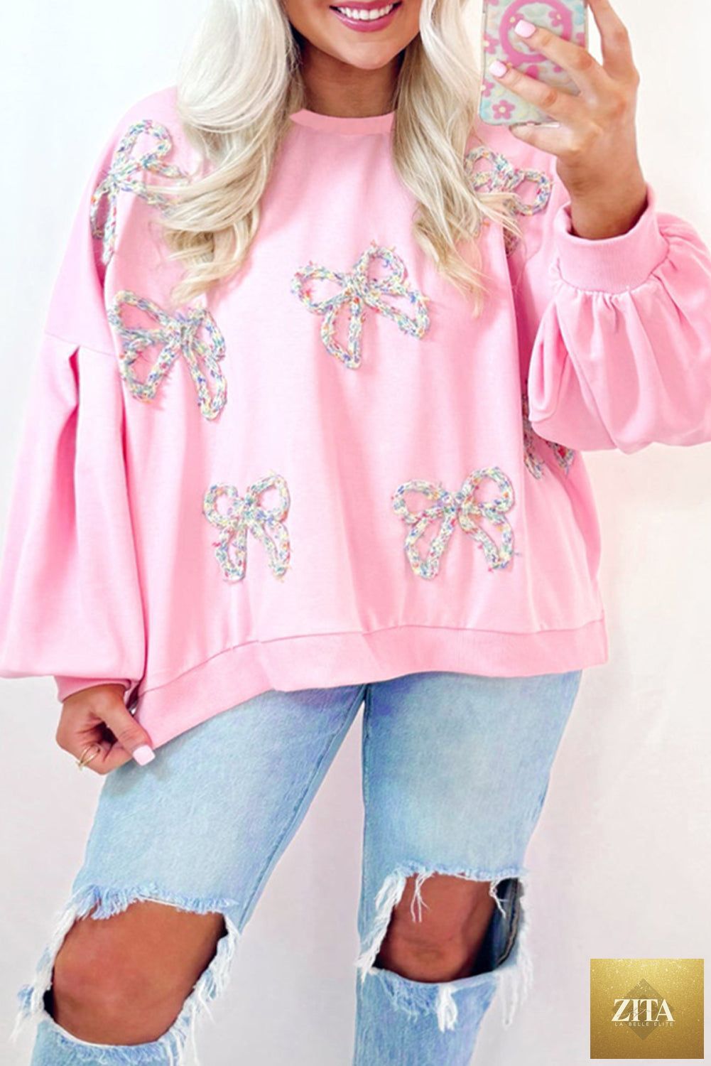Light pink embroidered bow lantern sleeve oversized sweatshirt by Unique Oils, featuring stylish puffed sleeves and cozy fit.
