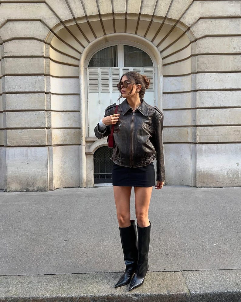 Vintage 90s oversized black leather bomber jacket by Cows Skin Jackets, distressed real leather, Parisian street style women’s outerwear.