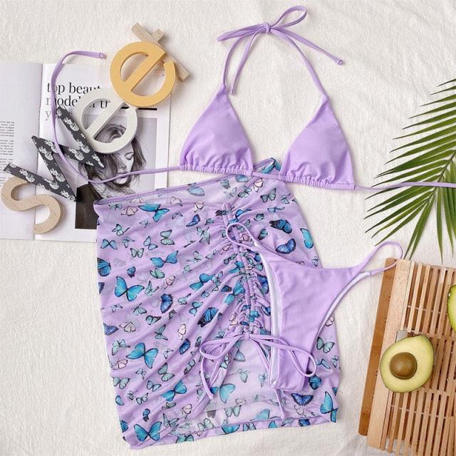 Stevvex 3-piece women's bikini set with high-cut swimsuit, halter top, wrap skirt, lace-up details, backless design and string accents.